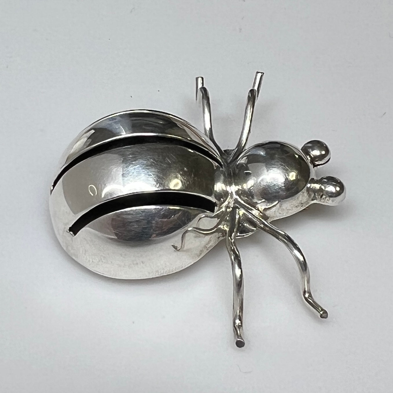 Side view of Taxco silver spider brooch showing dimensional body and leg detail