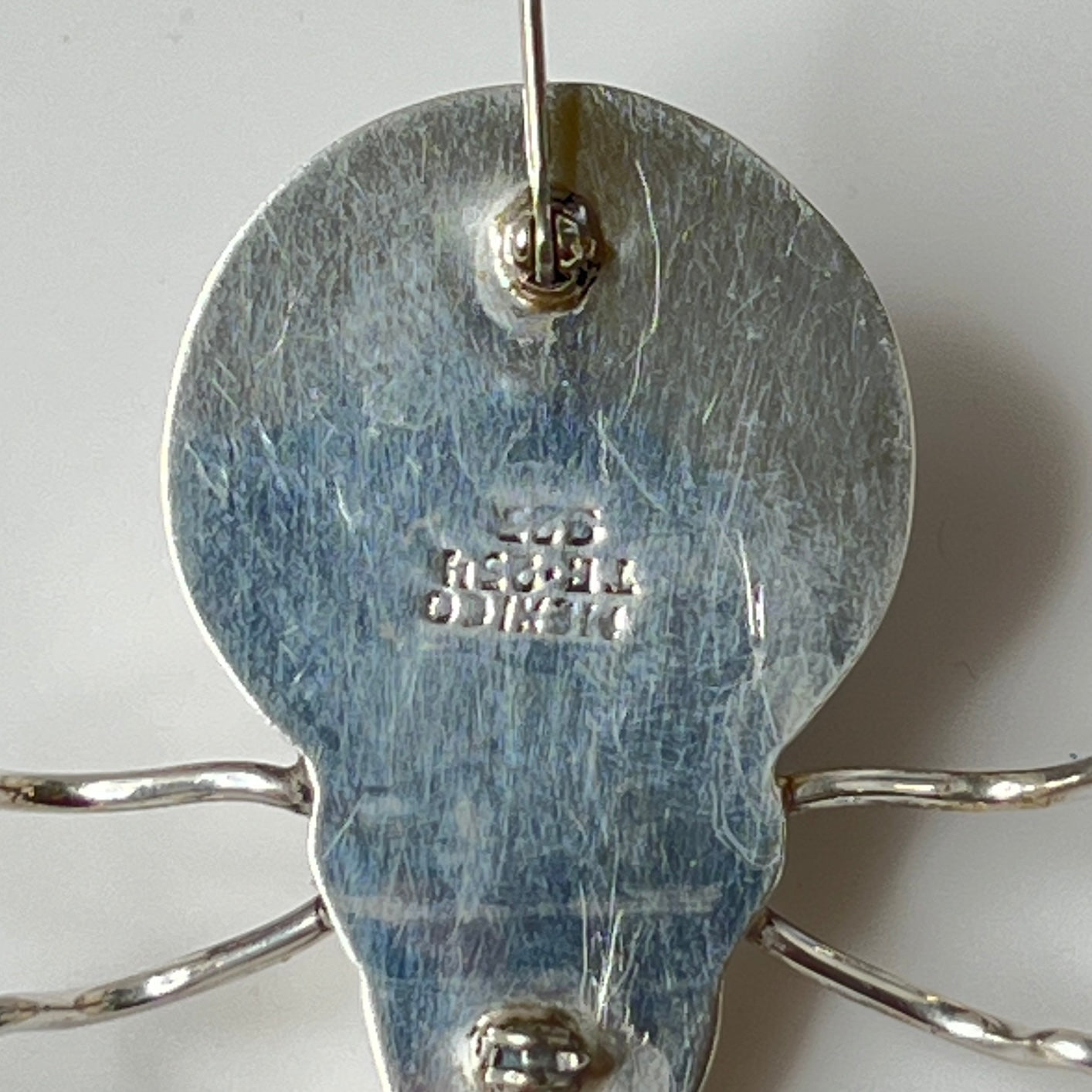 Sterling silver spider brooch with stylized body and curved legs