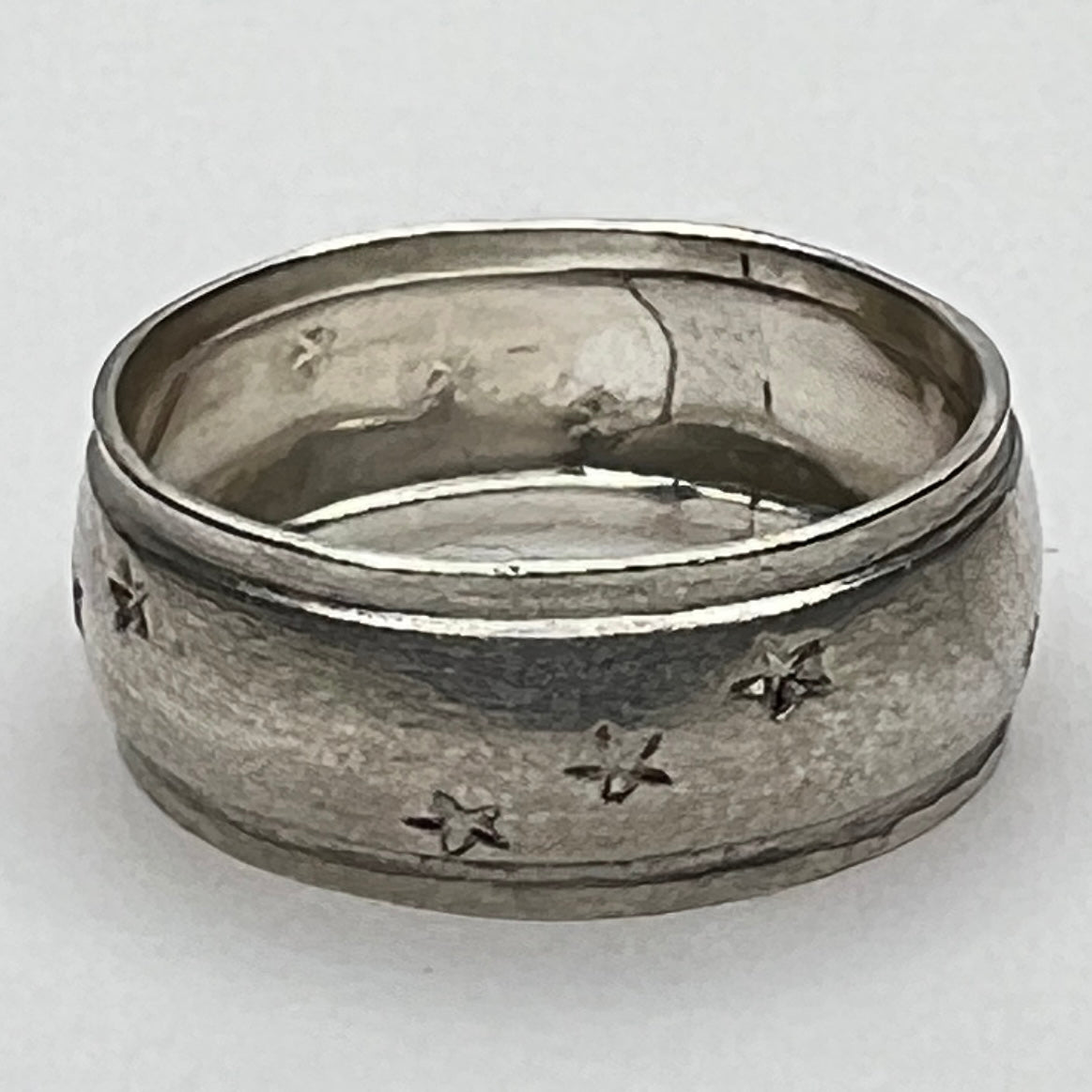 Close-up of engraved sterling ring with star pattern