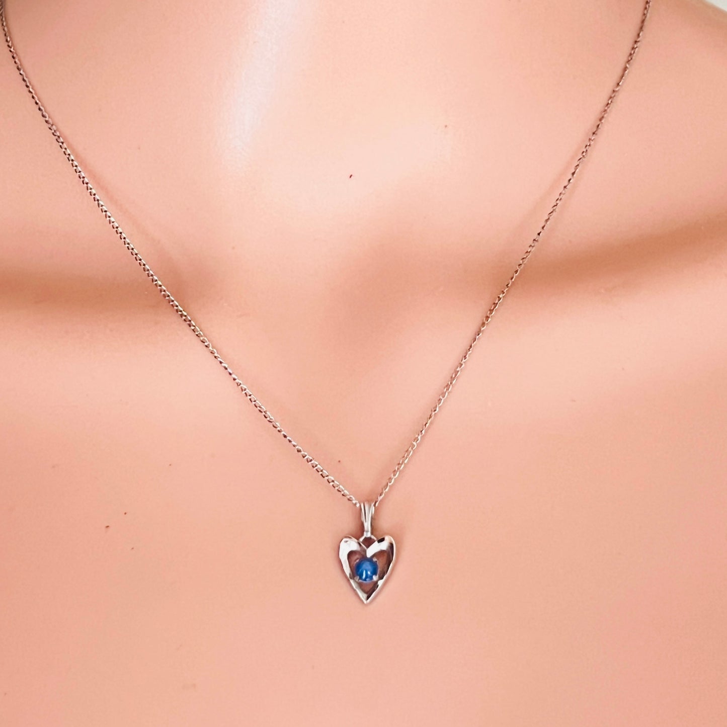 Sterling silver heart pendant with blue star sapphire on mannequin bust