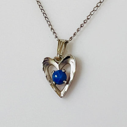 Close-up of sterling heart pendant with prong-set blue star sapphire