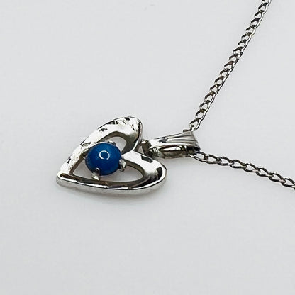 Close-up of sterling heart pendant with prong-set blue star sapphire