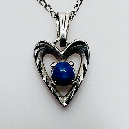 Close-up of sterling heart pendant with prong-set blue star sapphire