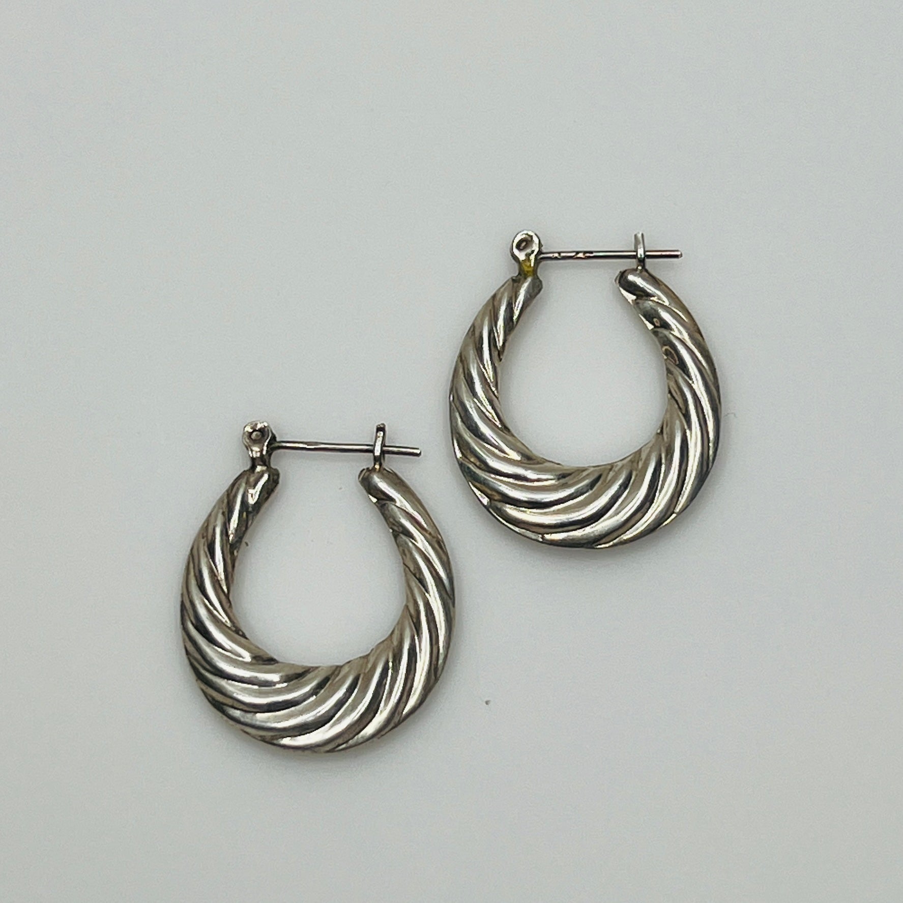 Pair of vintage sterling silver hoop earrings with swirl design