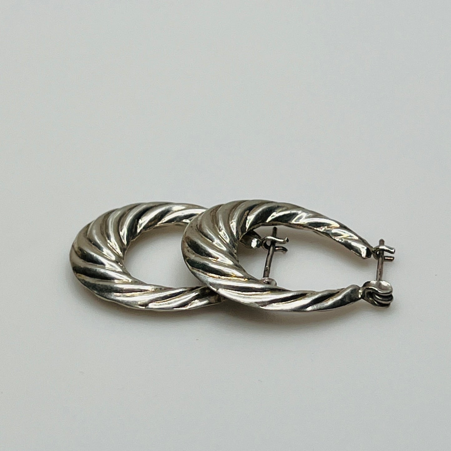 Pair of vintage sterling silver hoop earrings with swirl design