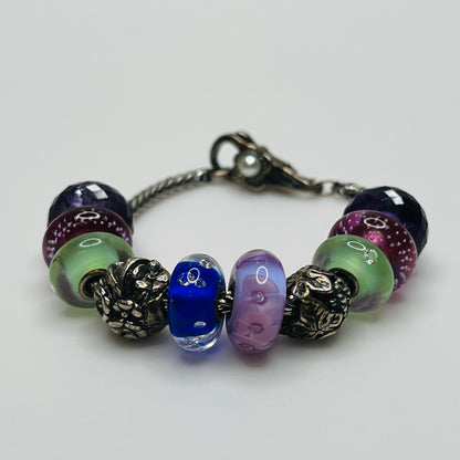 Close-up of sterling silver and glass charm bracelet with multicolored beads