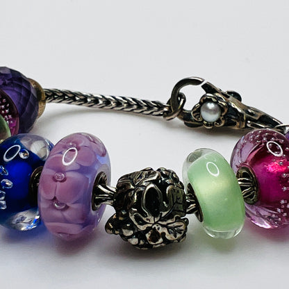 Close-up of sterling silver and glass charm bracelet with multicolored beads