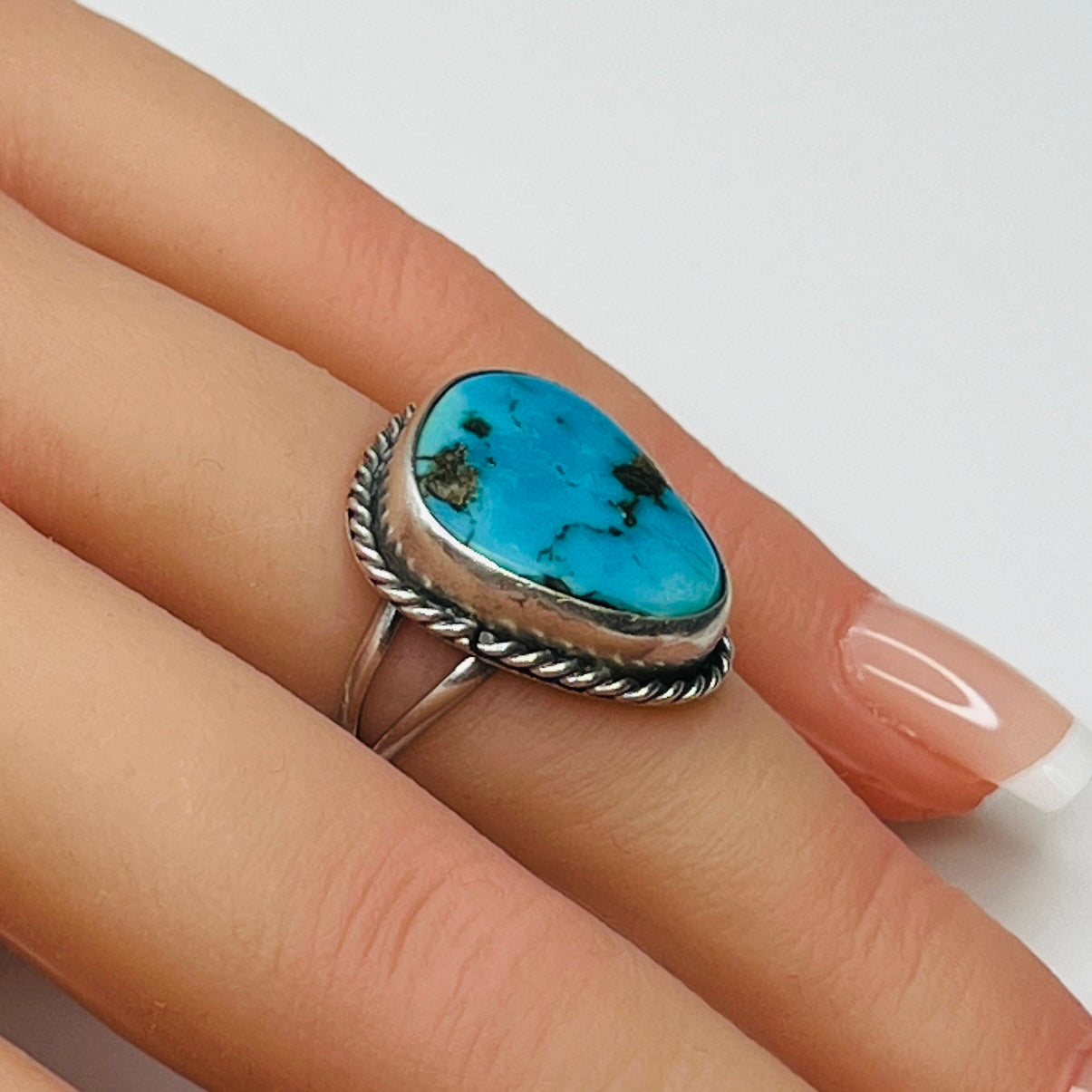 Sterling silver turquoise ring worn on finger, teardrop shape