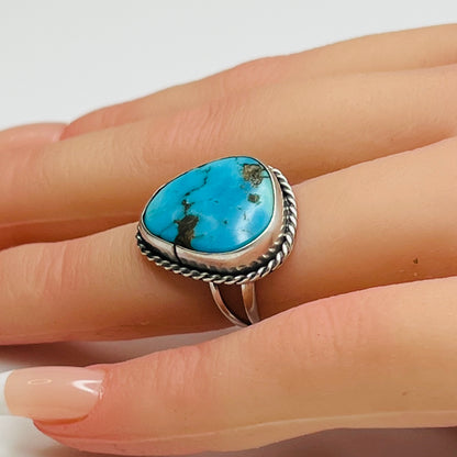 Sterling silver turquoise ring worn on finger, teardrop shape