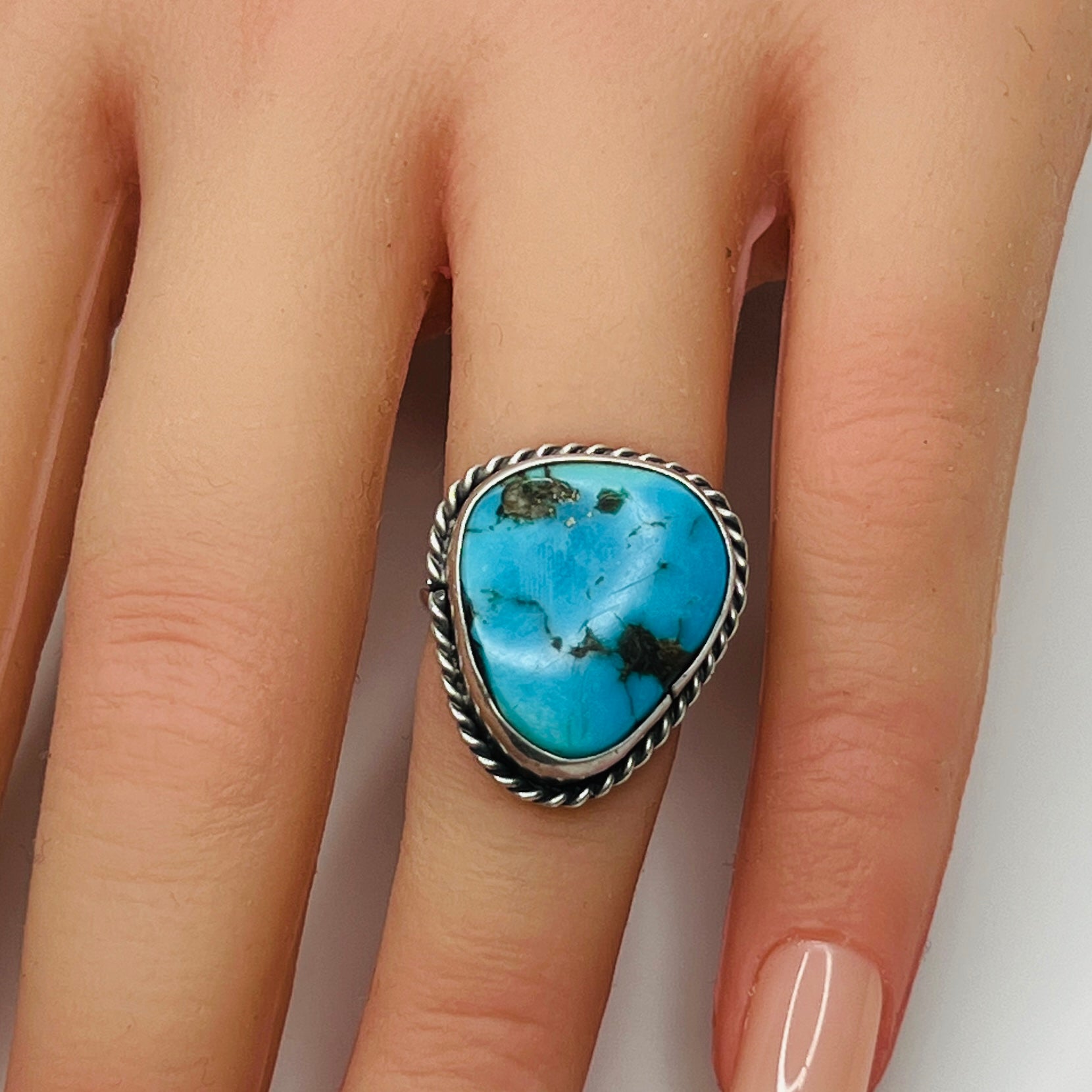 Sterling silver turquoise ring worn on finger, teardrop shape
