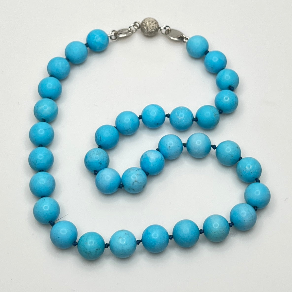 Close-up of turquoise beads with sterling magnetic clasp, laid flat