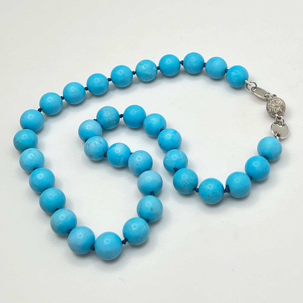 Close-up of turquoise beads with sterling magnetic clasp, laid flat