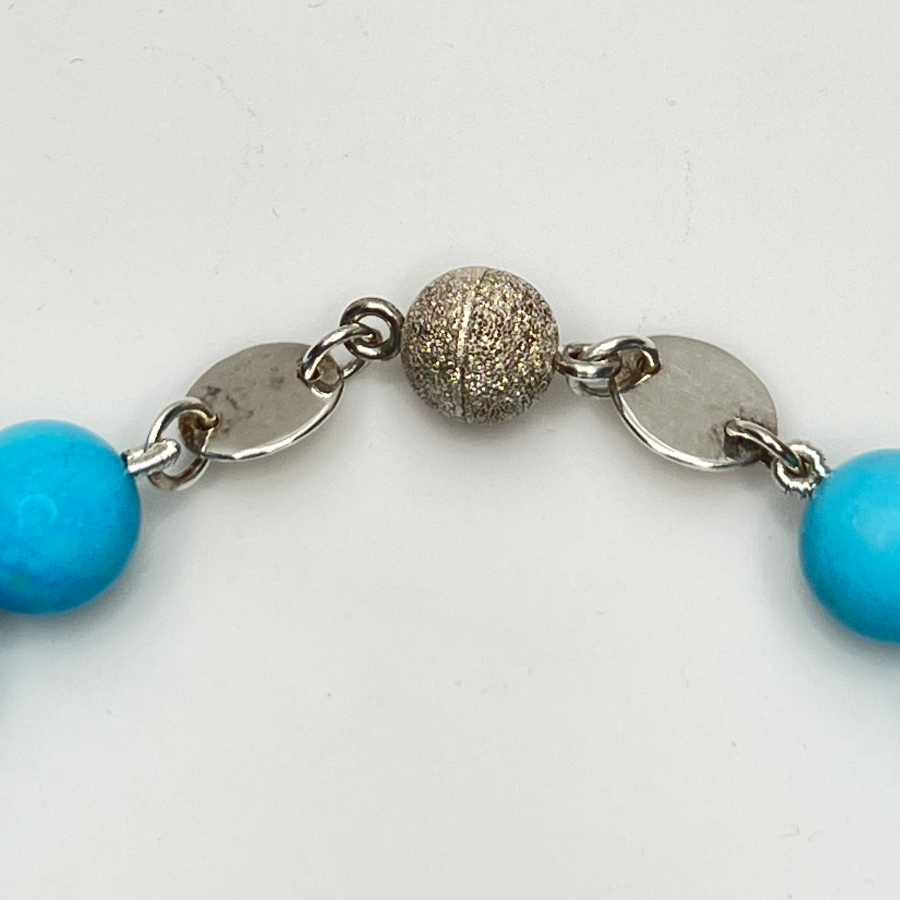 Close-up of turquoise beads with sterling magnetic clasp, laid flat