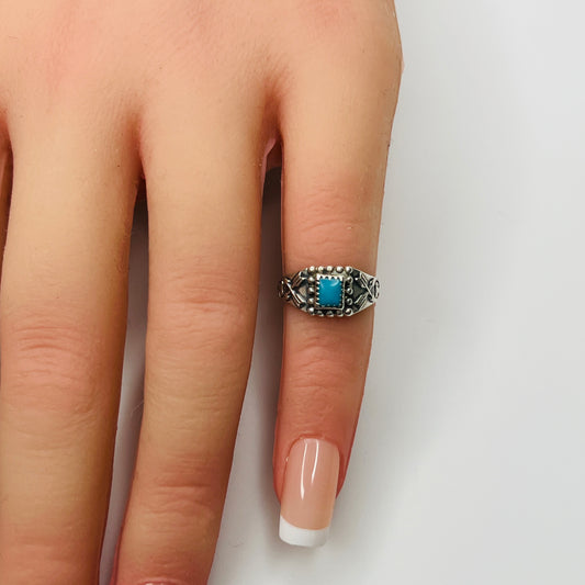 Sterling silver turquoise ring worn on mannequin hand as a pinky ring