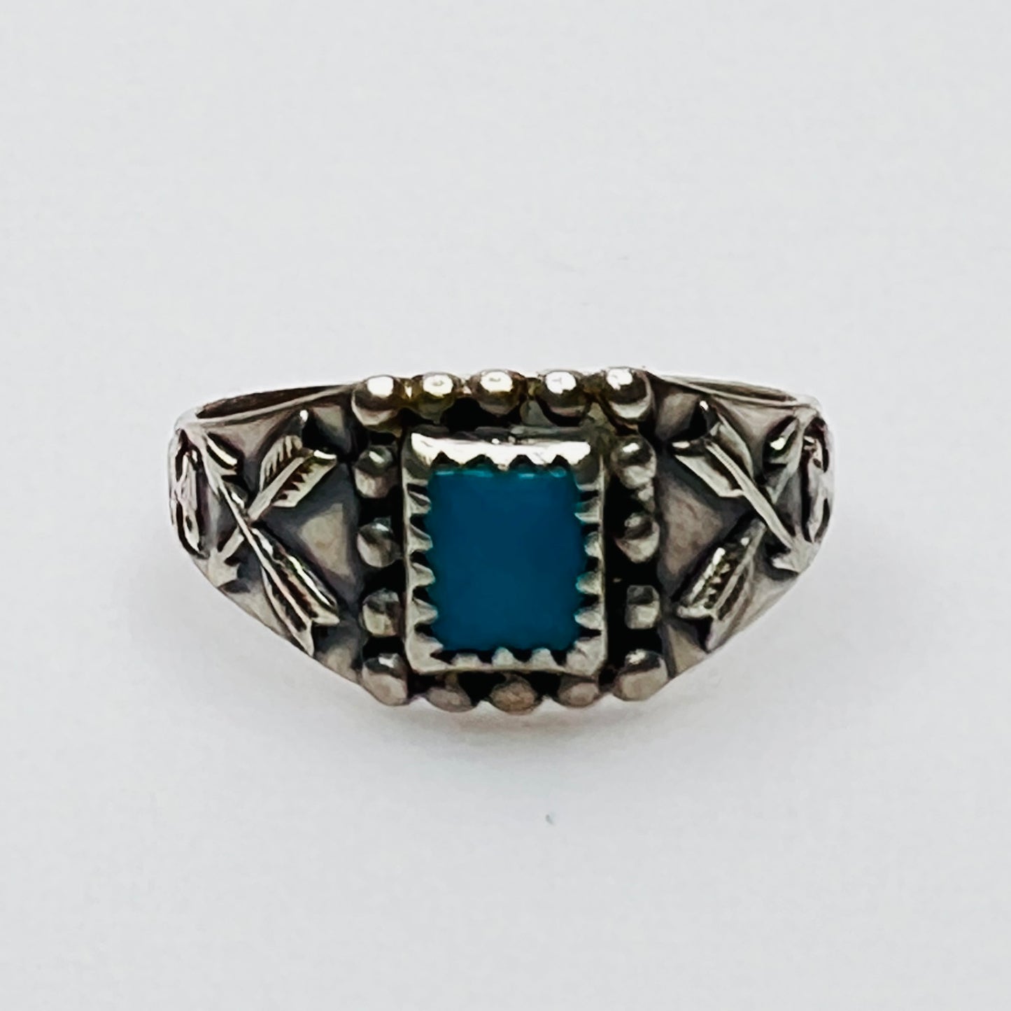 Front view of vintage turquoise ring with detailed bezel and side motifs
