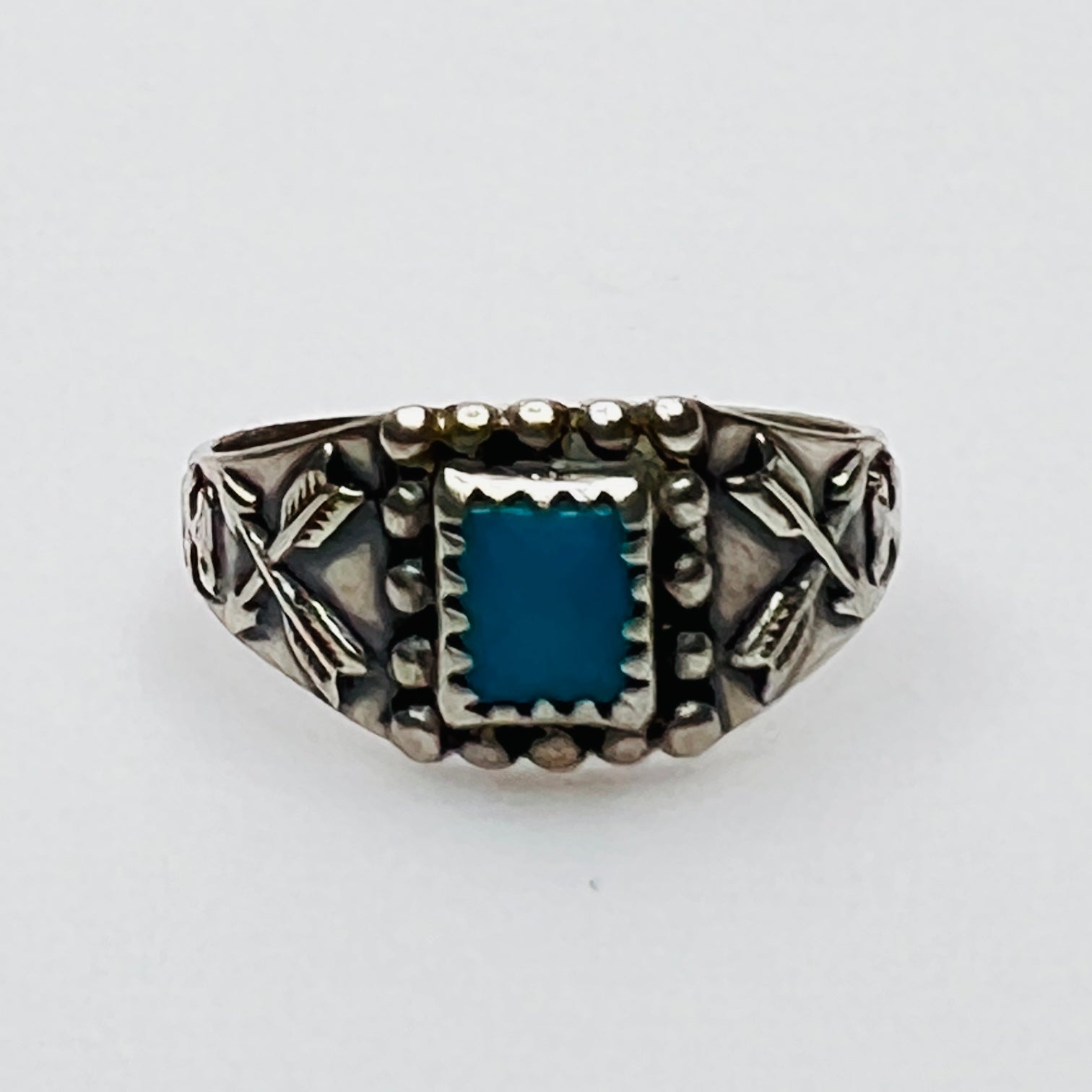 Front view of vintage turquoise ring with detailed bezel and side motifs