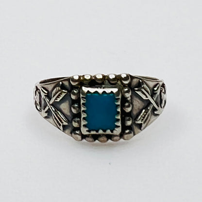 Front view of vintage turquoise ring with detailed bezel and side motifs