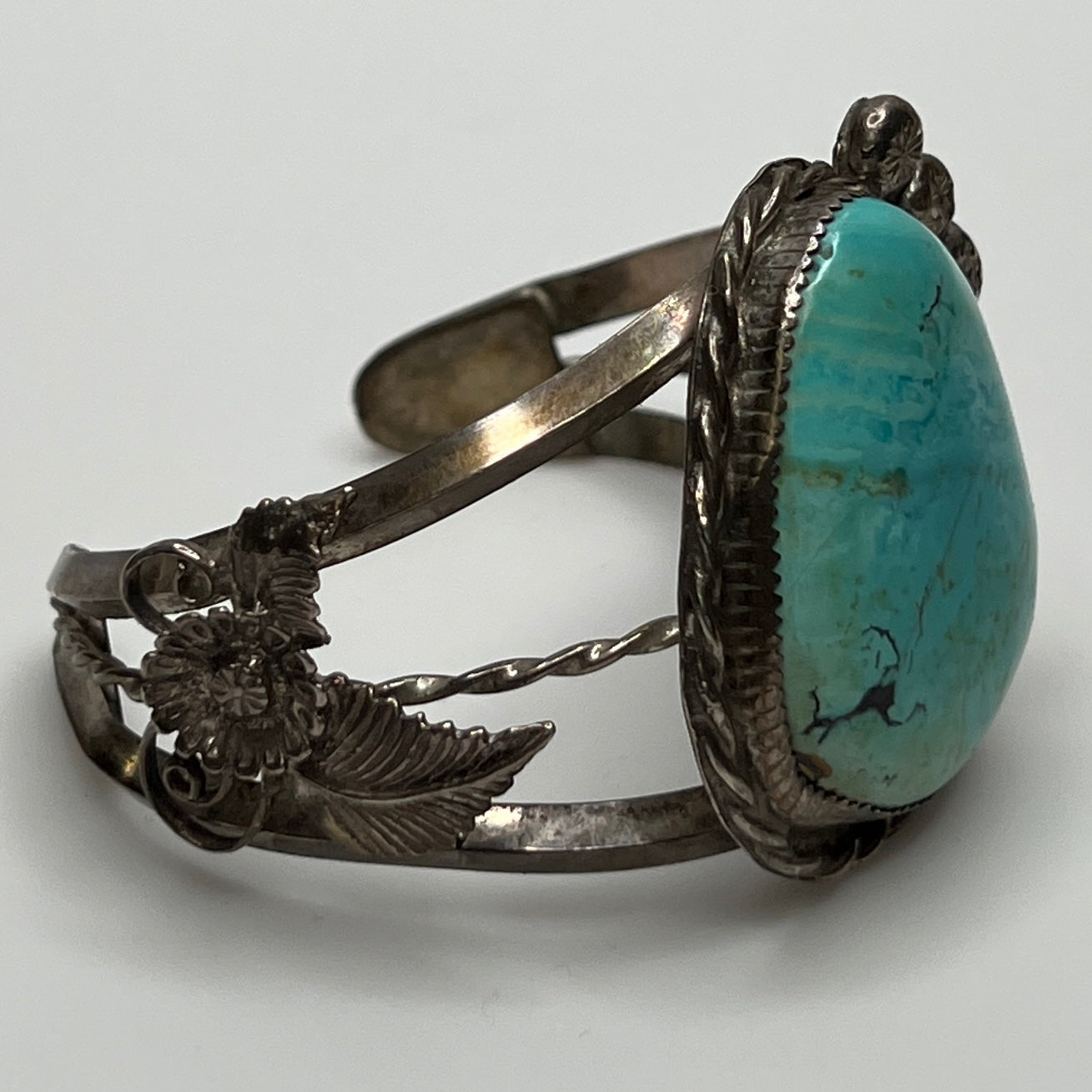 Side view of handcrafted sterling cuff with twisted wire and turquoise cabochon