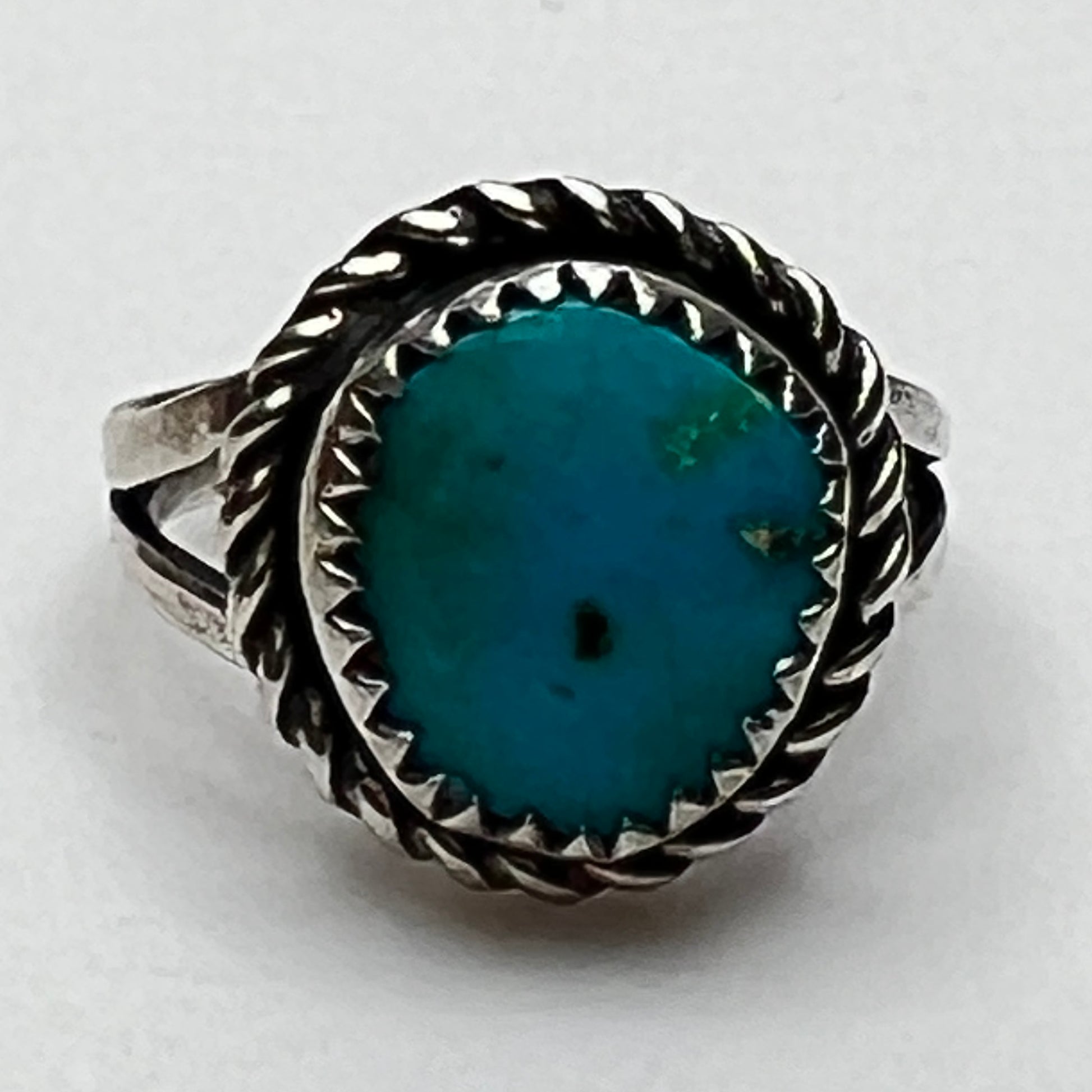 Close-up of oval turquoise stone with rope-edge bezel