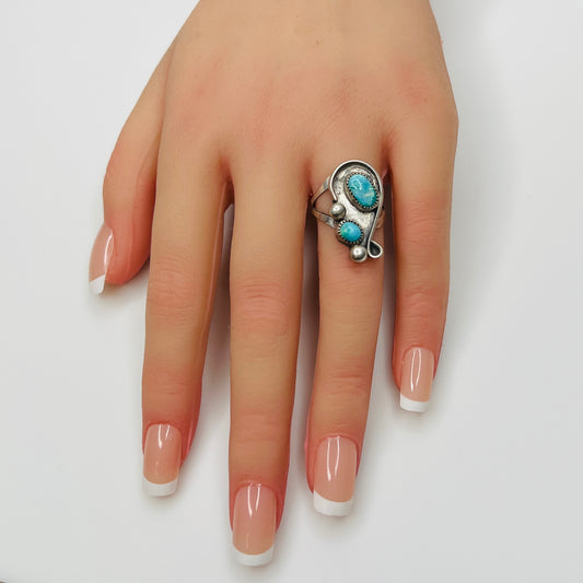 Handmade sterling silver ring with turquoise cabochons on model’s hand