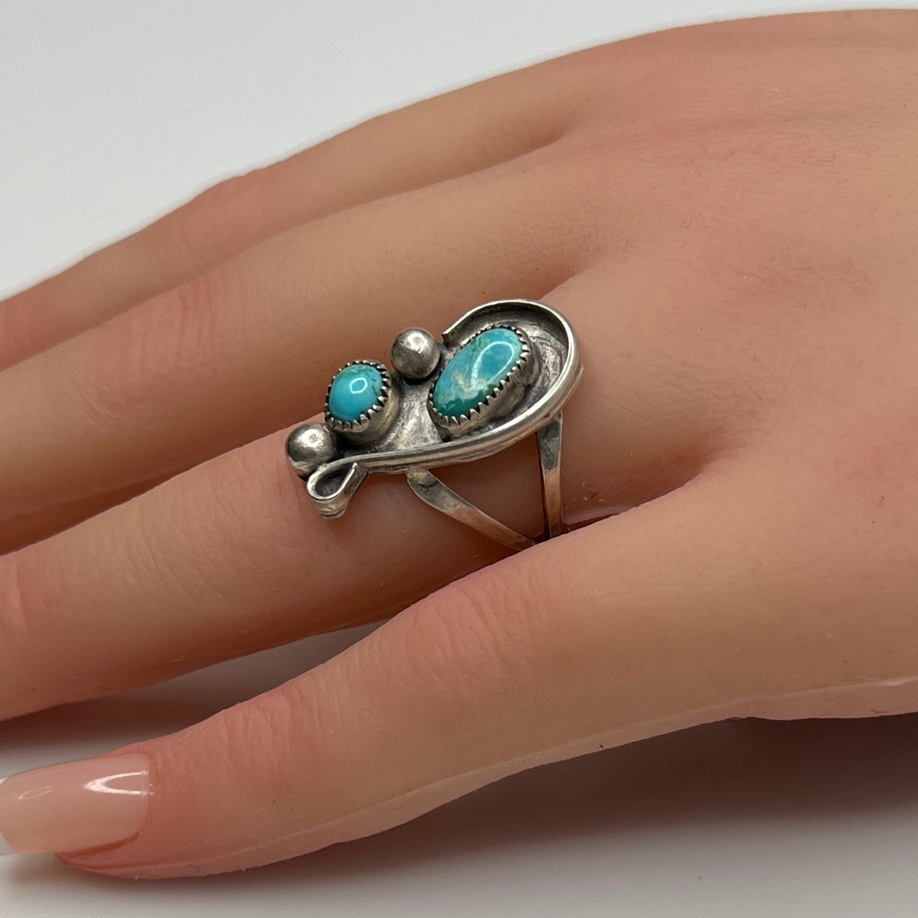 Handmade sterling silver ring with turquoise cabochons on model’s hand
