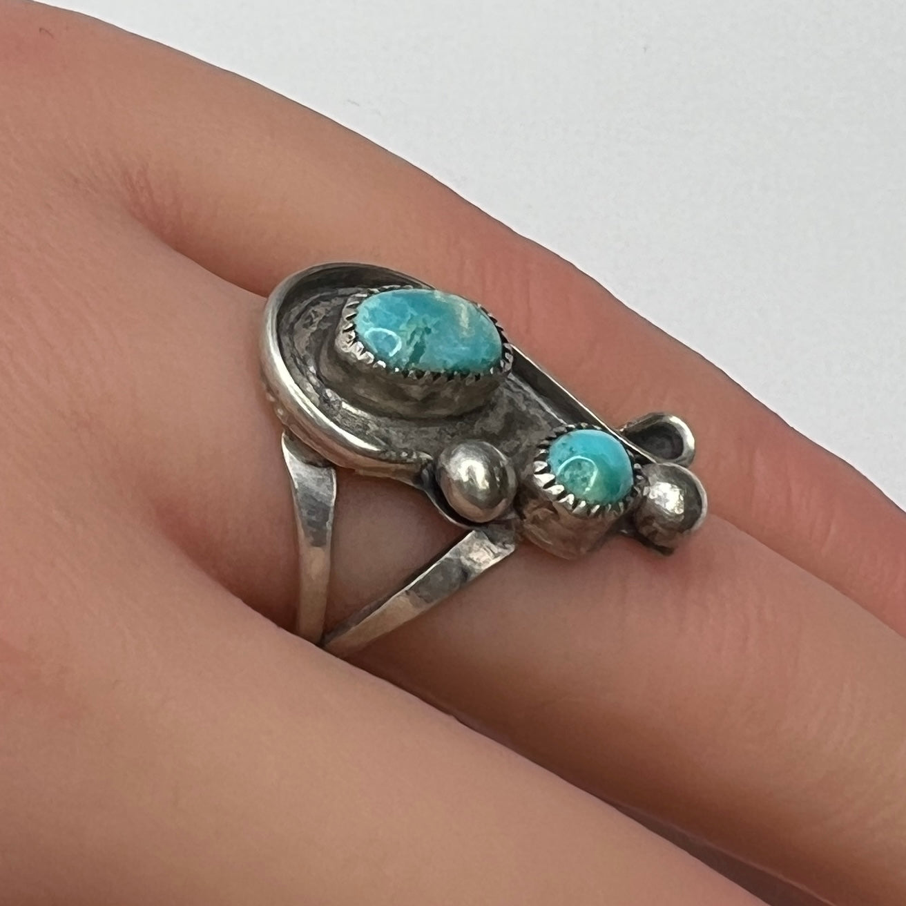 Handmade sterling silver ring with turquoise cabochons on model’s hand