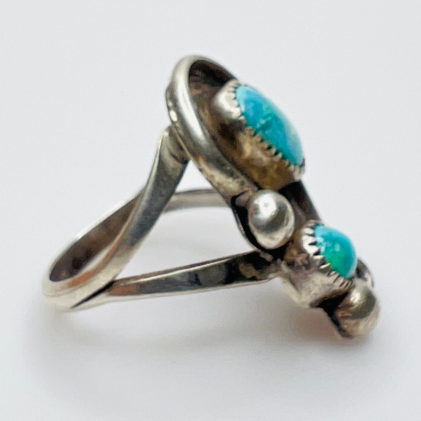 Side view of split shank silver ring with turquoise stones
