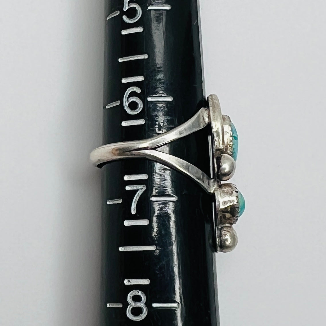 Ring on sizer showing size 6.5 and sculpted sterling design