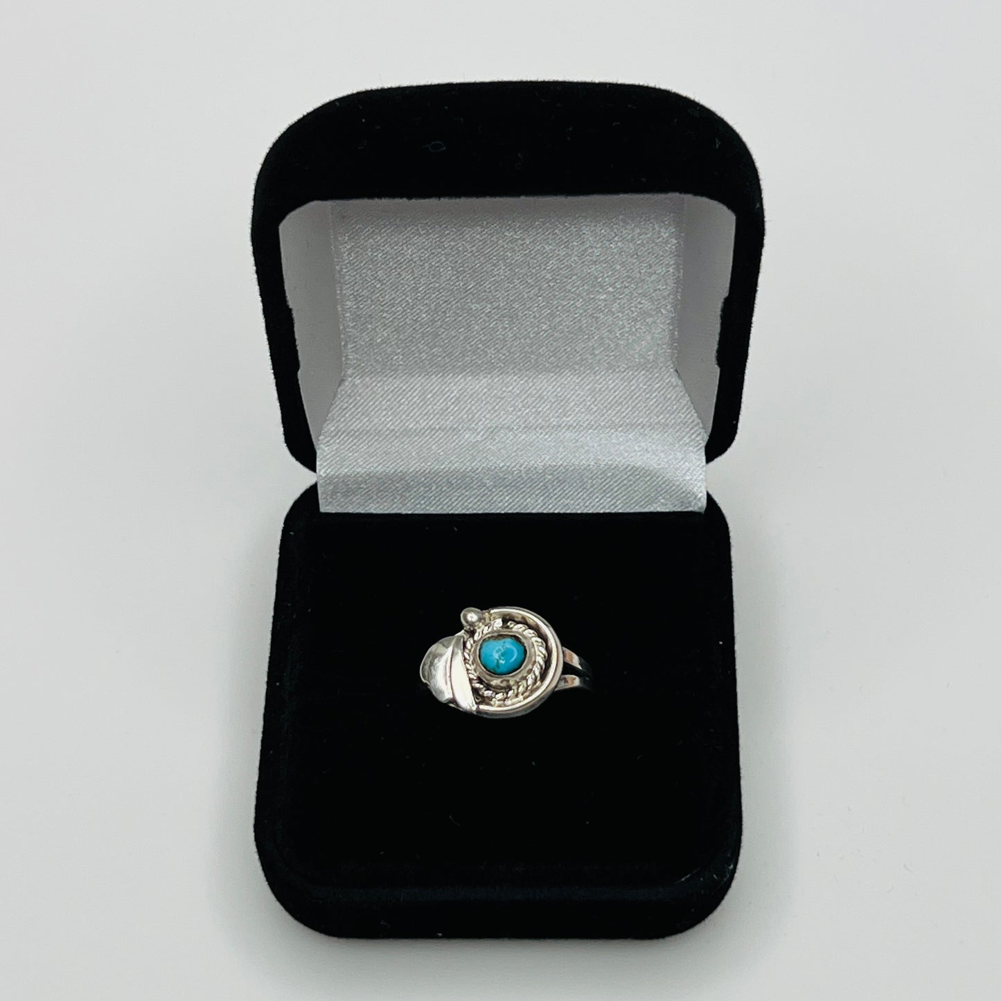 Close-up of turquoise ring showing rope and leaf motif