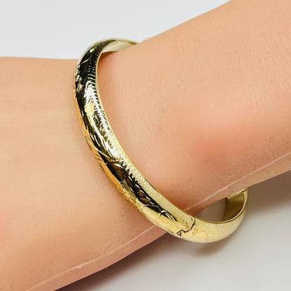 Gold vermeil etched bangle bracelet on wrist – floral engraved detail
