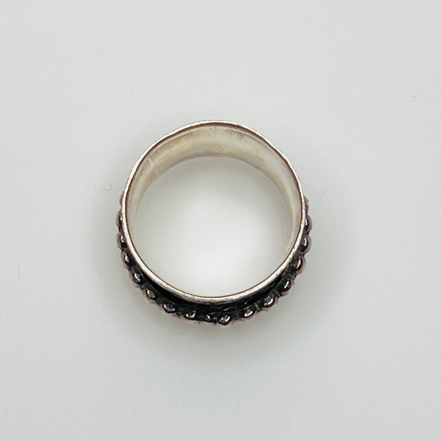 Wide sterling silver spinner ring with floral embossing, brass band, and beaded spinner