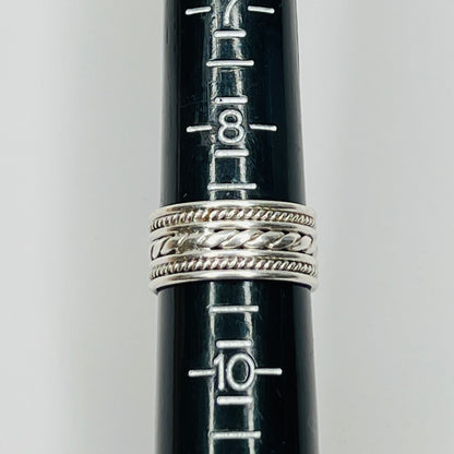 Close-up of textured braid and rope design on ring band on ring sizer