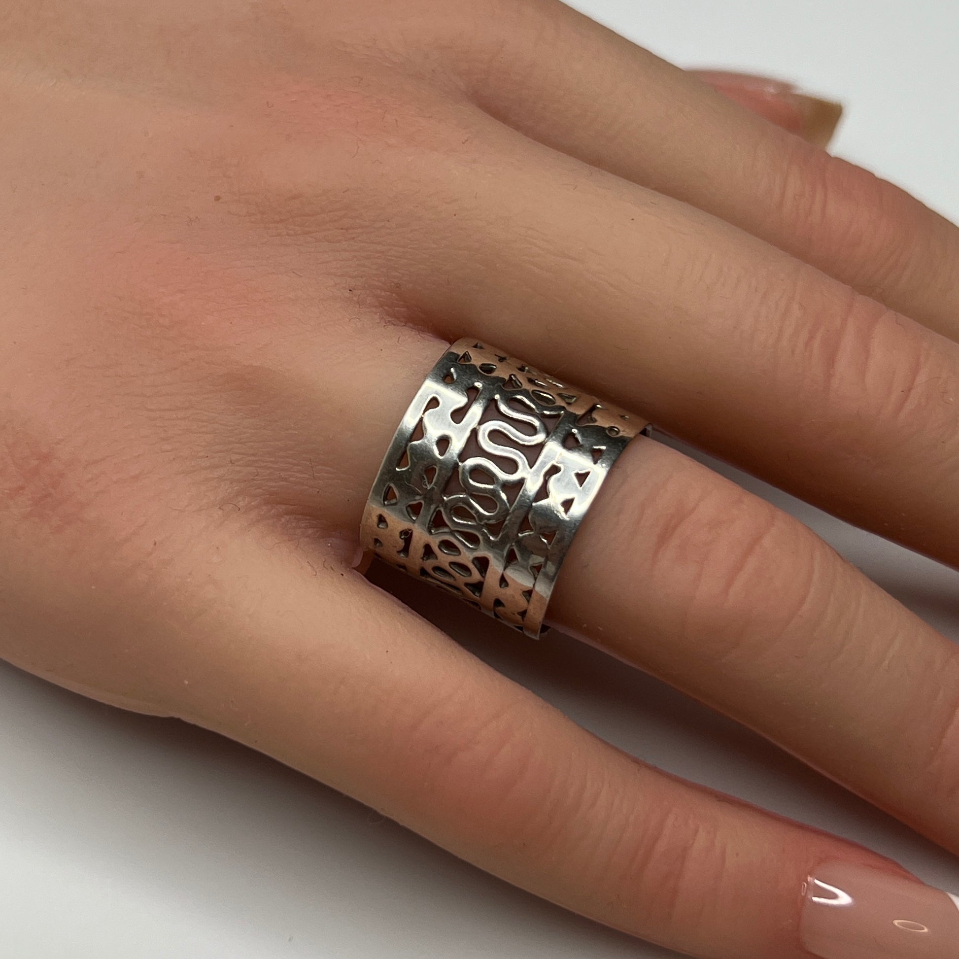 Sterling silver wide swirl cutout ring on hand, mid-century modern design