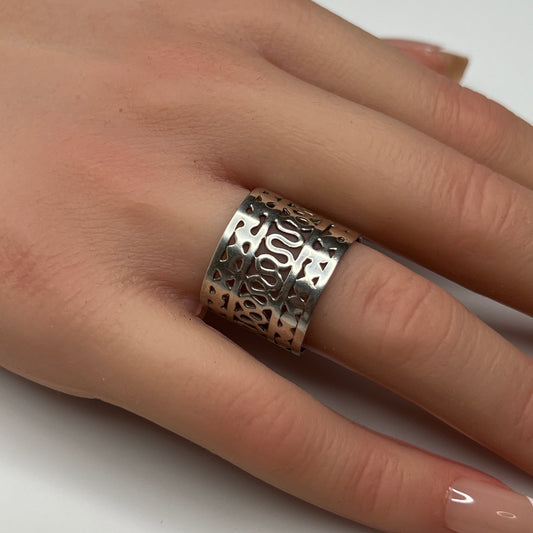Sterling silver wide swirl cutout ring on hand, mid-century modern design