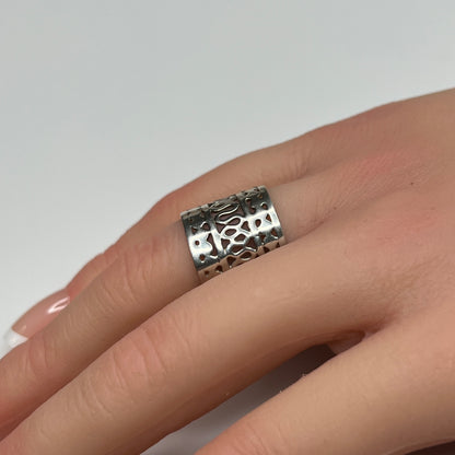 Sterling silver wide swirl cutout ring on hand, mid-century modern design