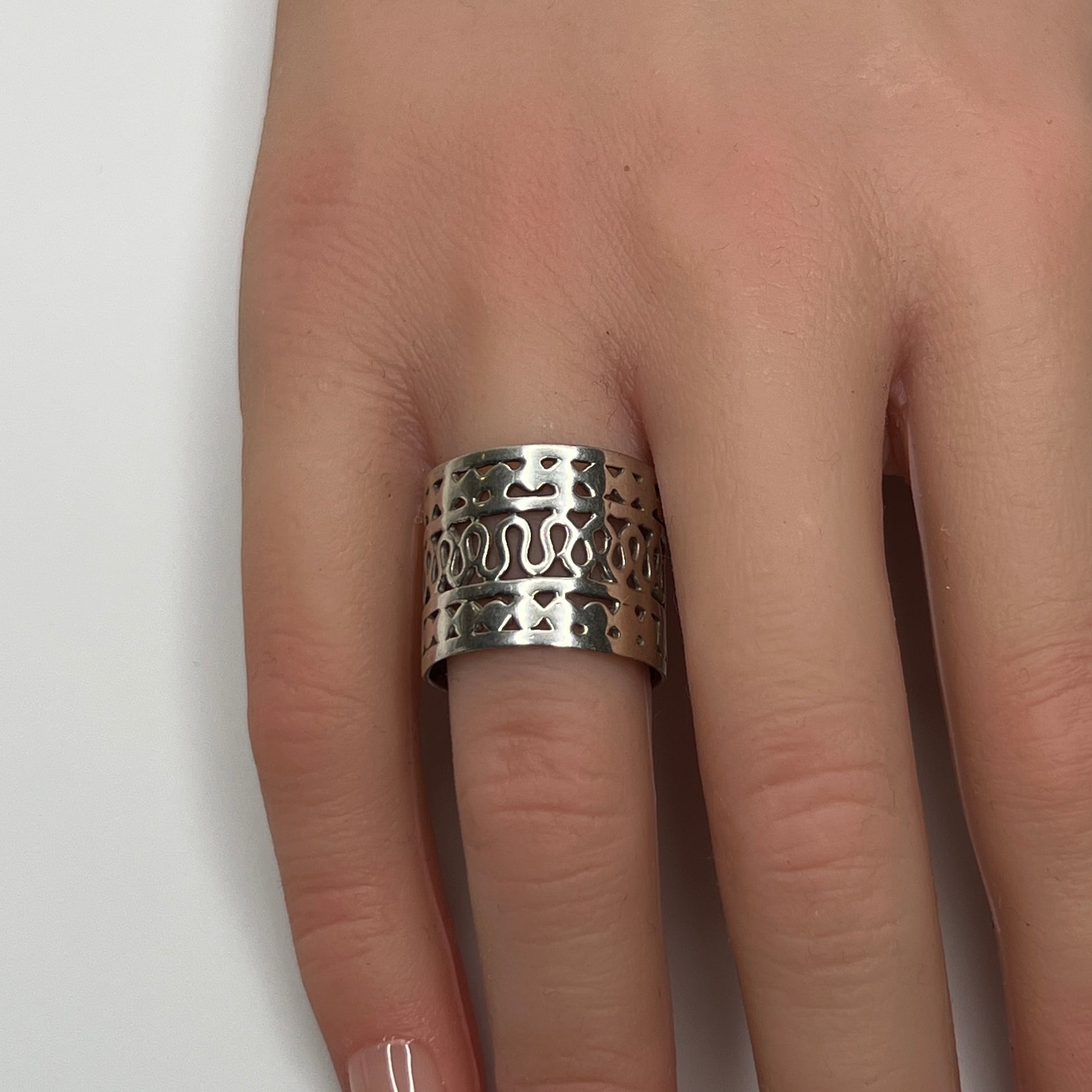 Sterling silver wide swirl cutout ring on hand, mid-century modern design