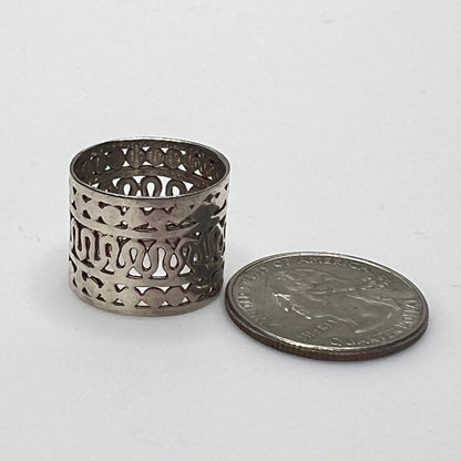 Close-up of openwork silver ring with swirling and geometric pattern