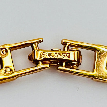 Close-up of fold-over clasp signed "Swarovski" in gold-tone metal
