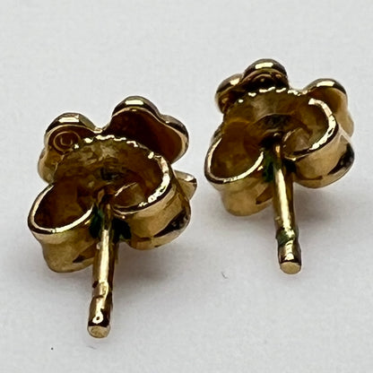 Tiny 14K gold shamrock stud earrings with green enamel cloverleaf design