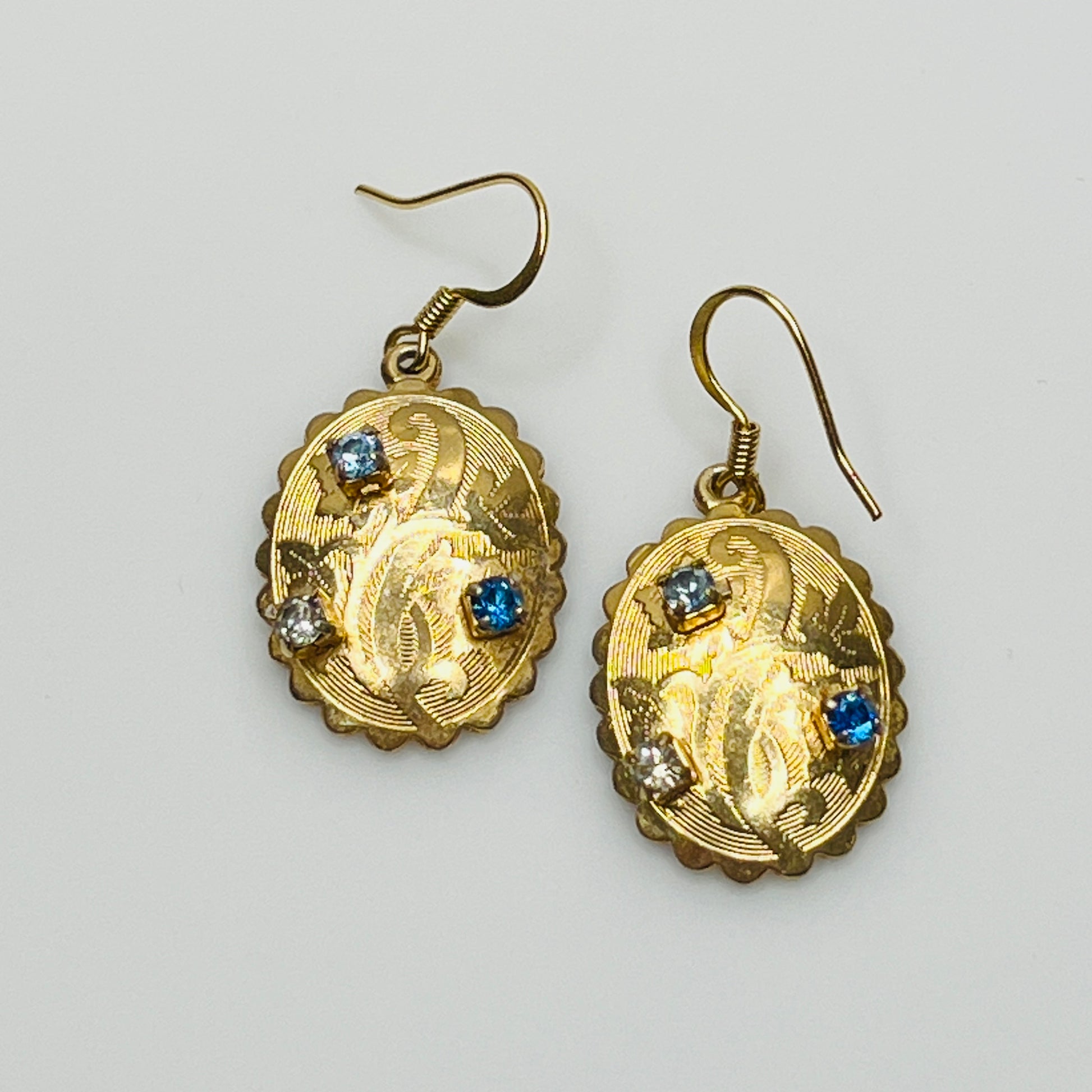 Gold-tone vintage dangle earrings with blue and clear rhinestones, ornate etched design