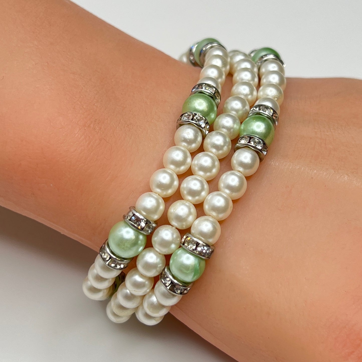 Three-strand faux pearl necklace and bracelet set with sage green pearls and rhinestone spacers.