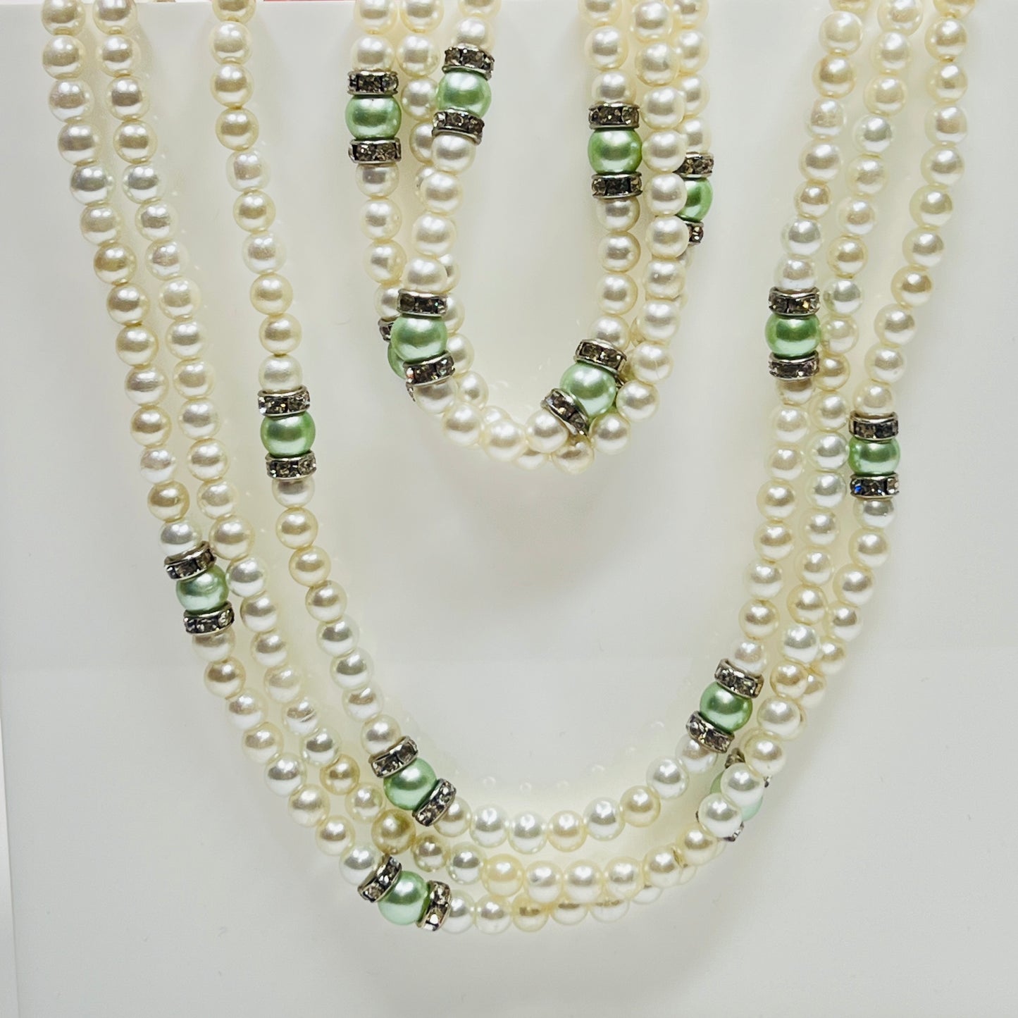 Three-strand faux pearl necklace and bracelet set with sage green pearls and rhinestone spacers.