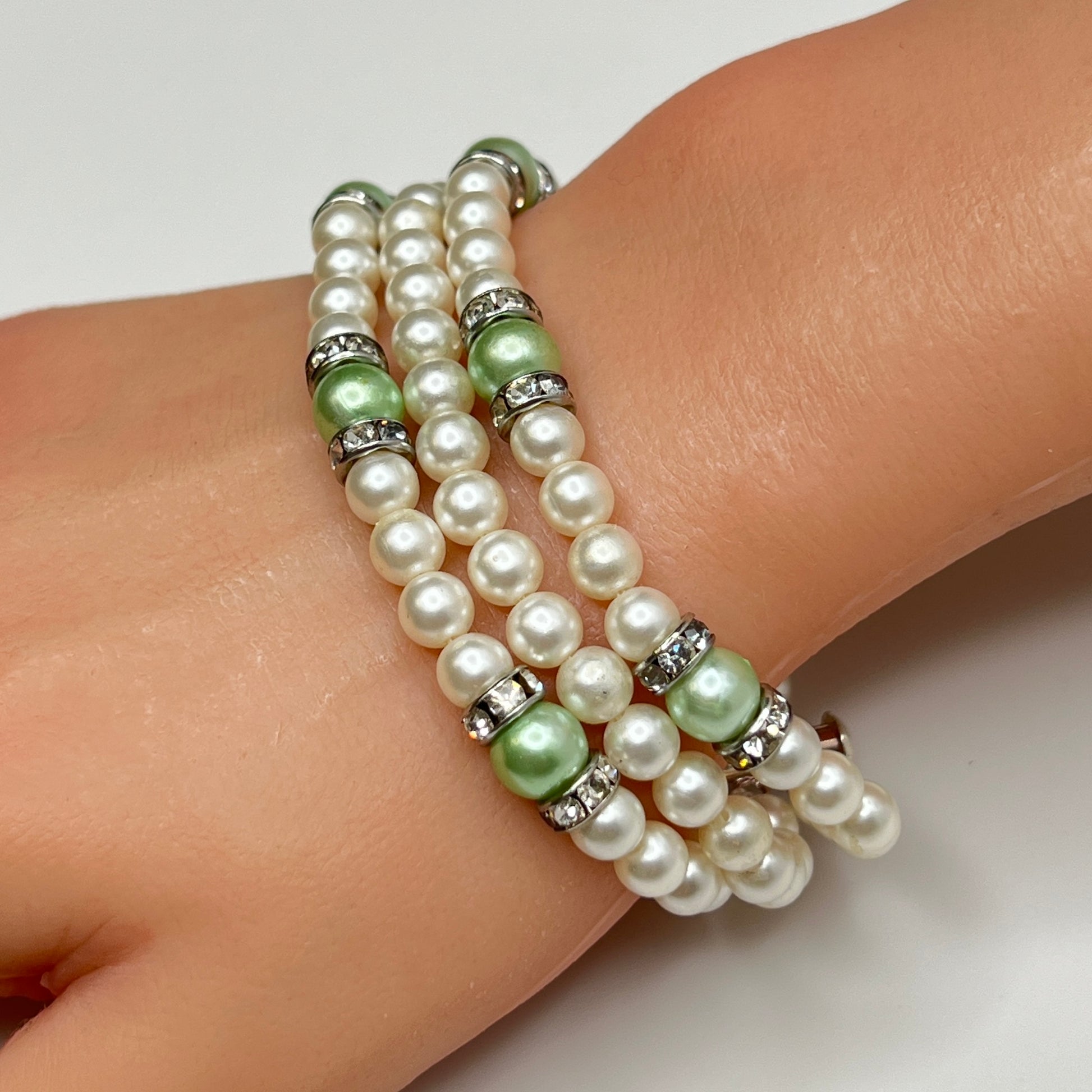 Three-strand faux pearl necklace and bracelet set with sage green pearls and rhinestone spacers.