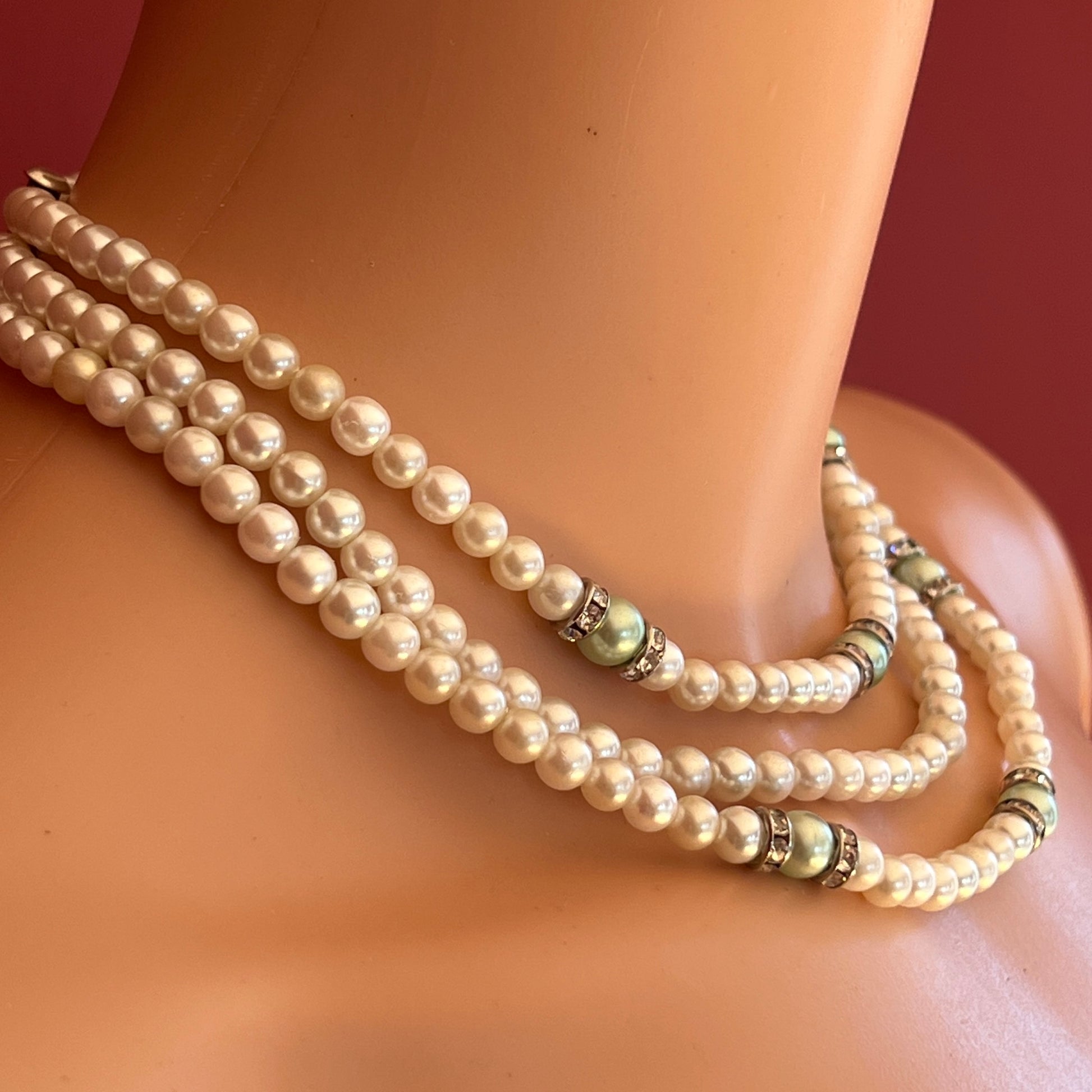 Three-strand faux pearl necklace and bracelet set with sage green pearls and rhinestone spacers.