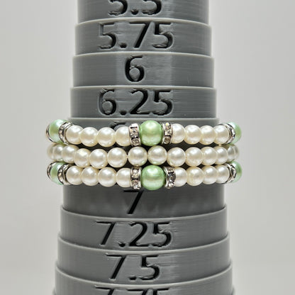 Three-strand faux pearl necklace and bracelet set with sage green pearls and rhinestone spacers.