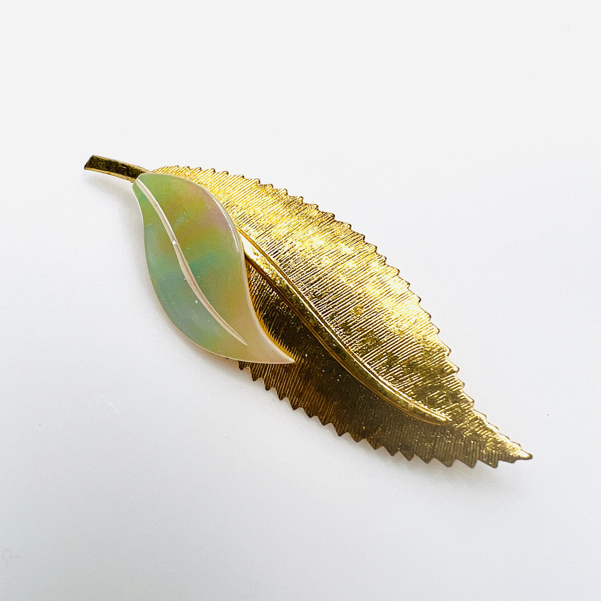 Vintage 1950s West Germany gold-tone leaf brooch with genuine iridescent mother of pearl accent and textured serrated leaf design.