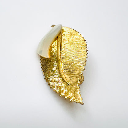 Side view of vintage 1950s gold-tone botanical brooch showing raised mother of pearl leaf and dimensional metal construction.