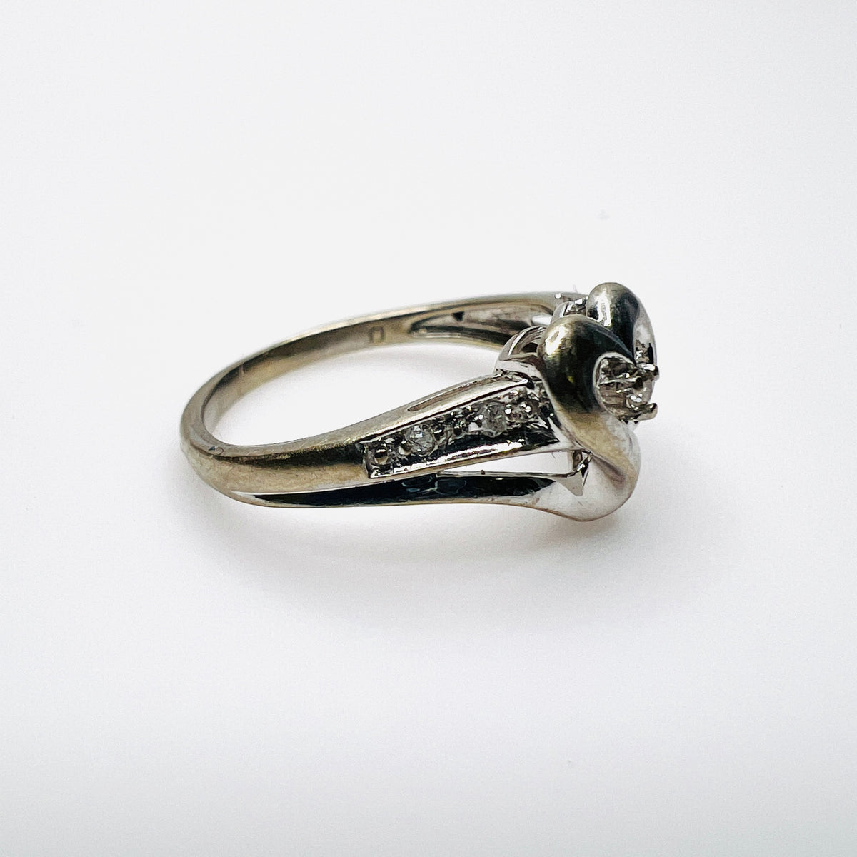 Side view of 10K white gold heart ring with diamond-set shoulders