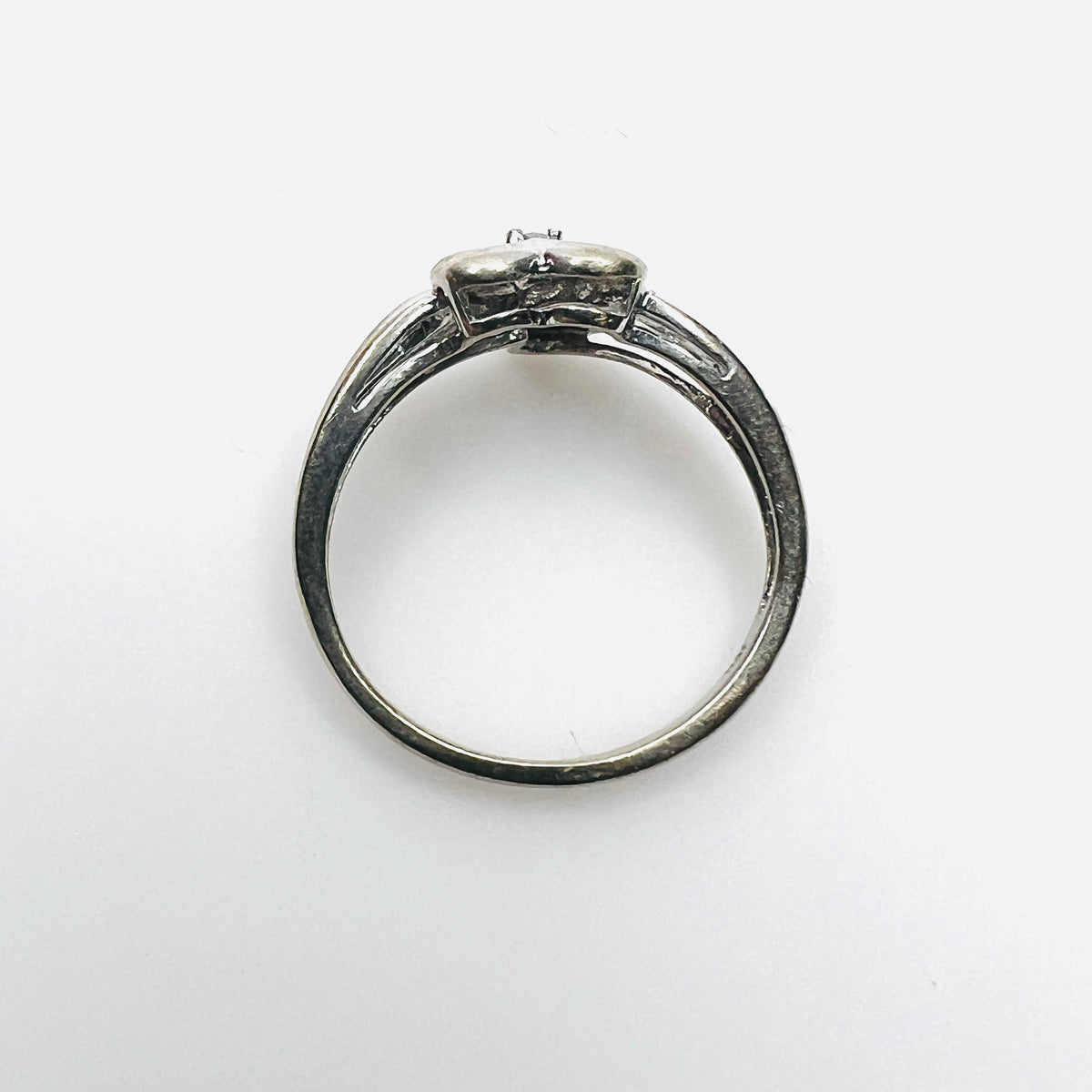 Top view of 10K white gold heart ring with diamond-set shoulders