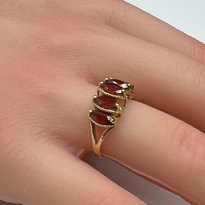 Vintage 10K gold ring with five marquise garnets on model’s hand